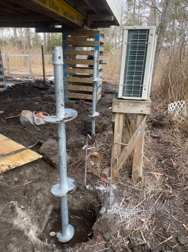 Helical piers being installed under a residential property (project 4)